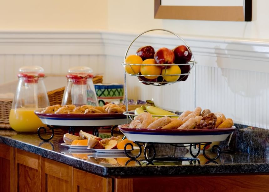 A table with Fruits, snacks, and juice at Juniper Hill Inn by Ogunquit Collection