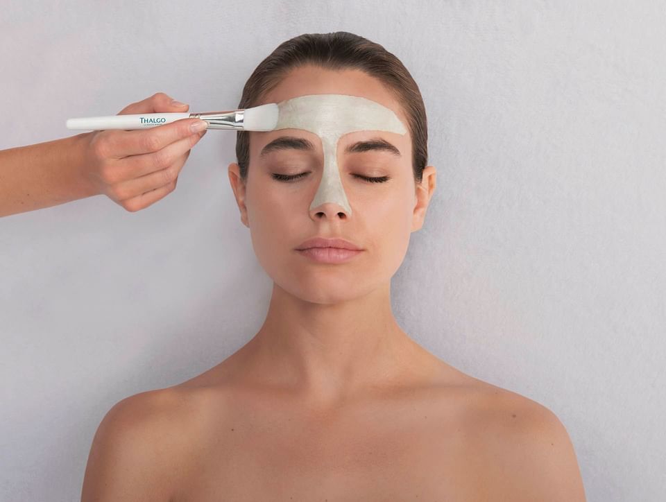 Woman receiving a facial treatment with a brush at Thalgo Spa, The Saujana Hotel Kuala Lumpur