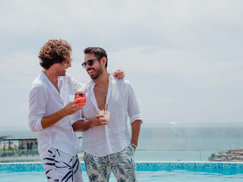 2 hombres conversando y disfrutando de un trago en la terraza del Resort The Reef 28