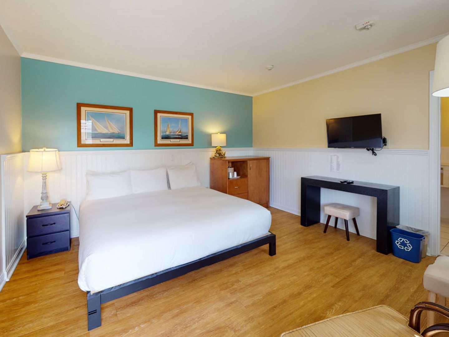 Wall-mounted TV with work desk by the bed in One King - ADA at Breezeway Boutique Hotel