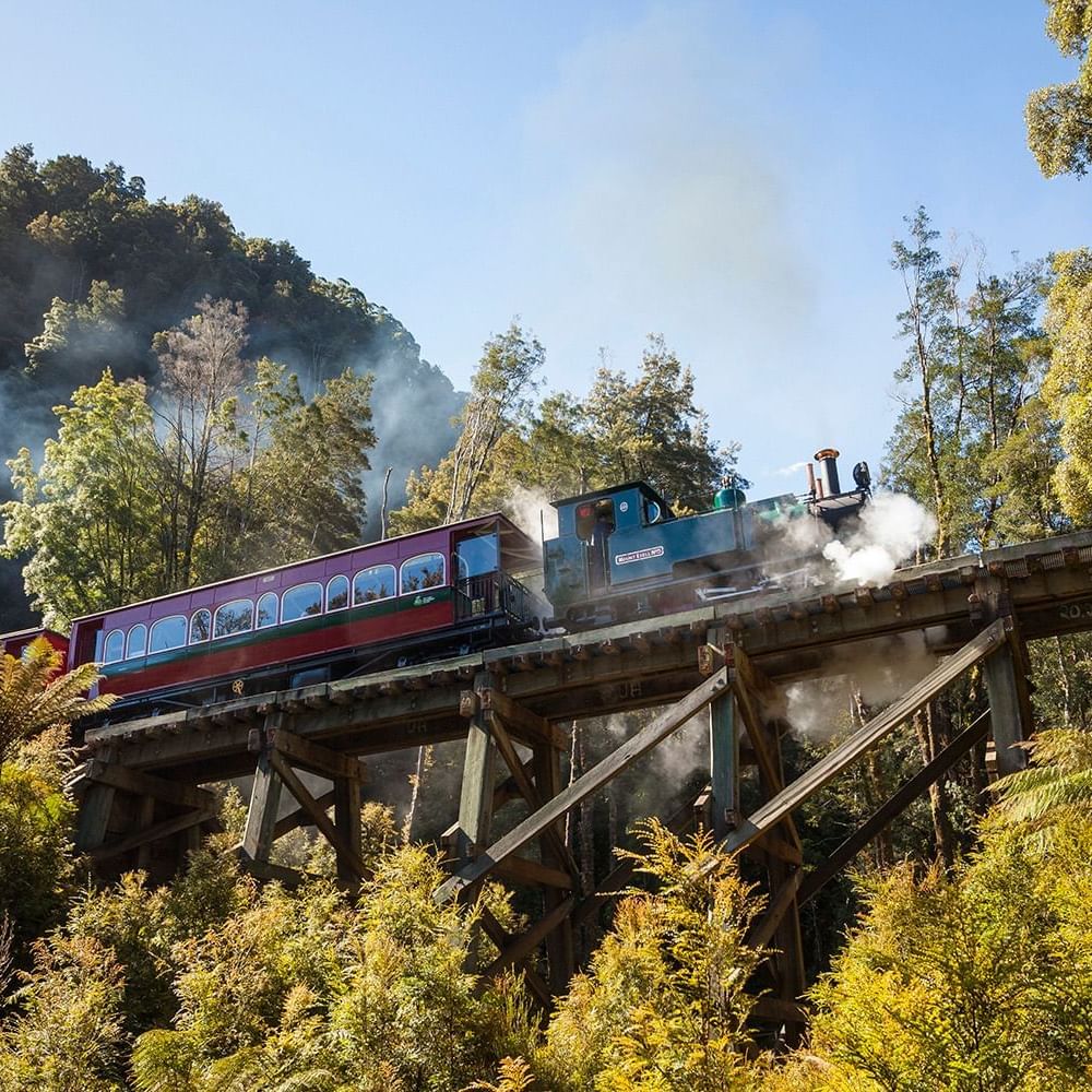 A Train running on a bridge near Strahan Village Hotel