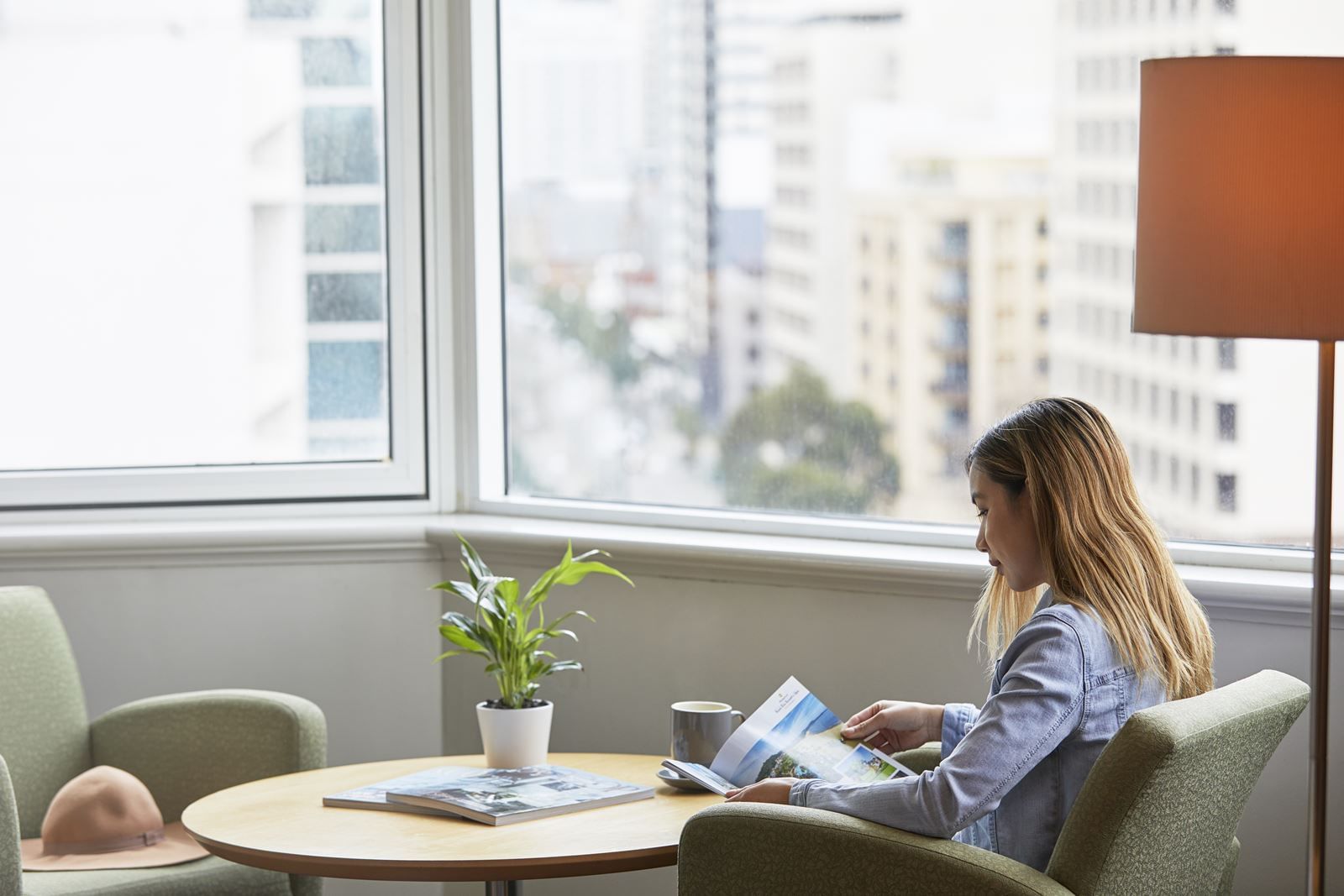 woman is perusing the Novotel Perth Langley hotel magazine |  Accommodation Perth CBD | Accommodation Perth WA