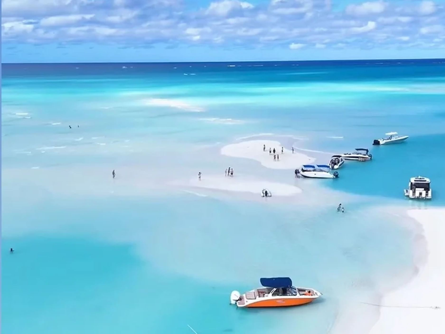 Aerial view of people enjoying the sunny paradise with their boats near Windsong Resort On The Reef