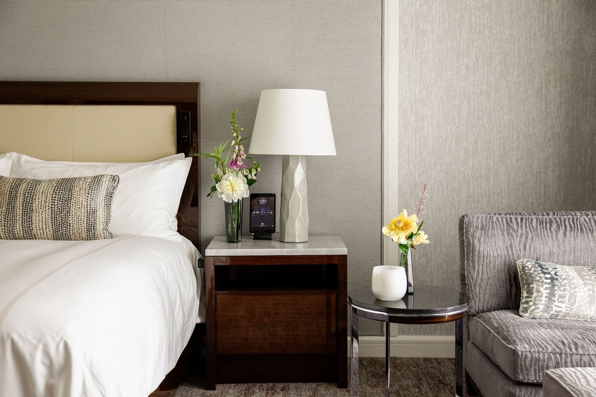 Nightstand with flowers & a lamp in a Suite at Umstead Hotel and Spa