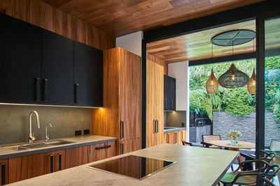 Sleek kitchen with cabinets, a view of a garden, and a dining area in Casa Cielo at Singular Signature Residences