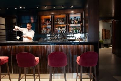 A Bartender making drinks by the bar counter at Matrix Hotel