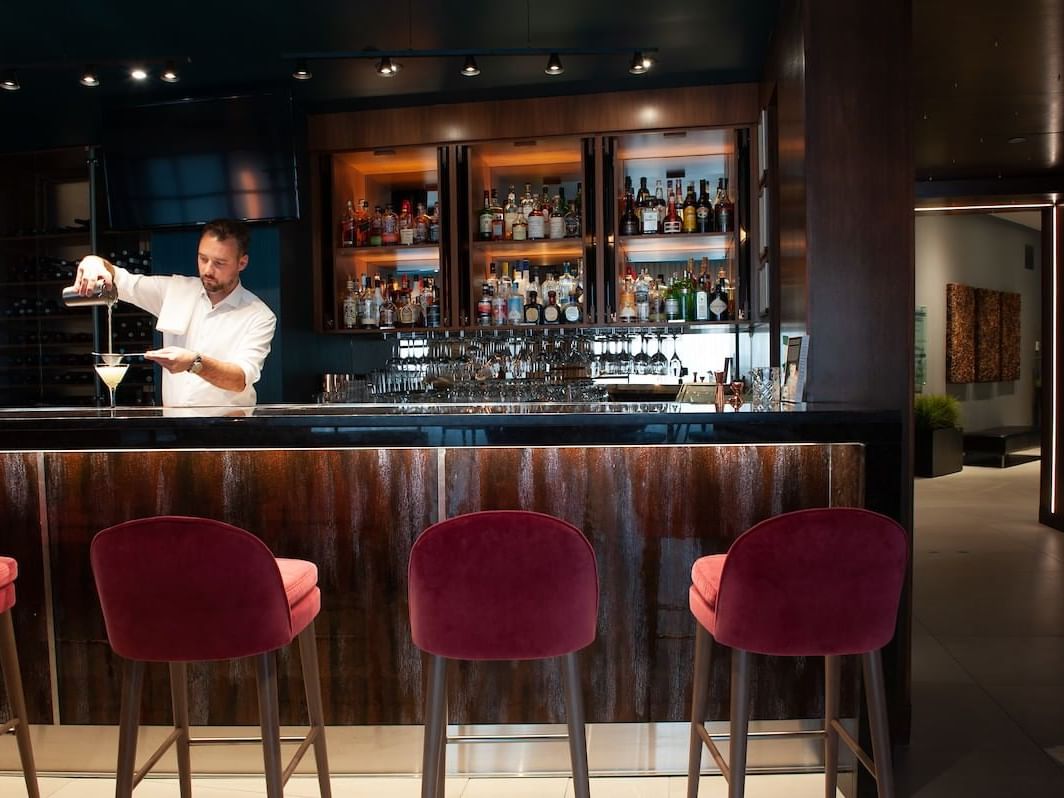 A Bartender making drinks by the bar counter at Matrix Hotel