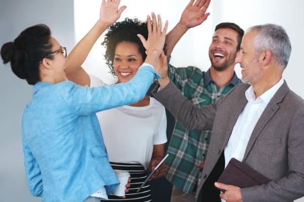 Hybrid and remote teams high fiving each other at team building events which has united them