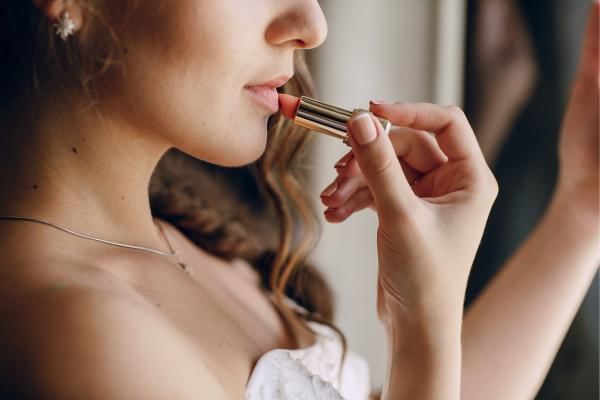 Bride putting on lipstick, part of what was in her wedding day emergency kit for the bride