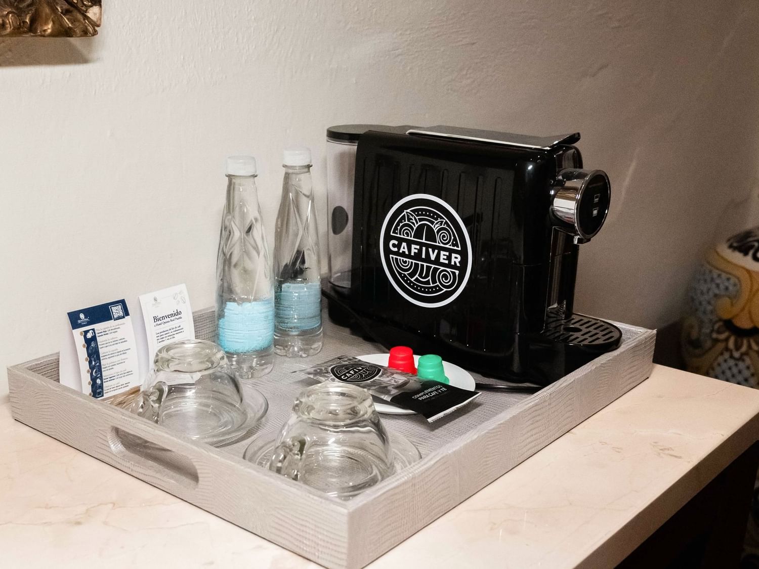 Bandeja con cafetera, botellas y vasos en Suite Presidencial King de Quinta Real Puebla en Heroica Puebla de Zaragoza
