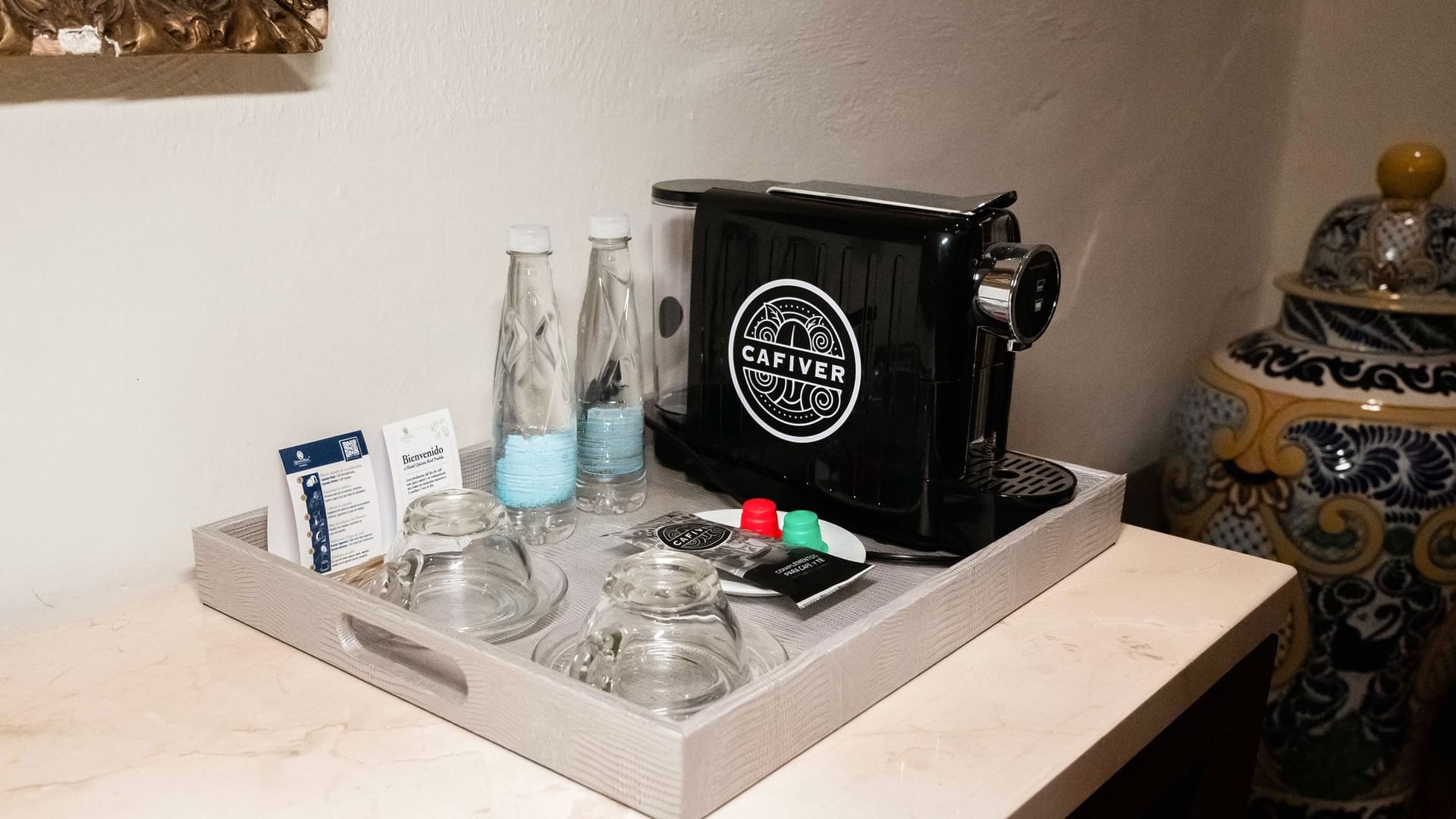 Bandeja con cafetera, botellas y vasos en Suite Presidencial King de Quinta Real Puebla en Heroica Puebla de Zaragoza
