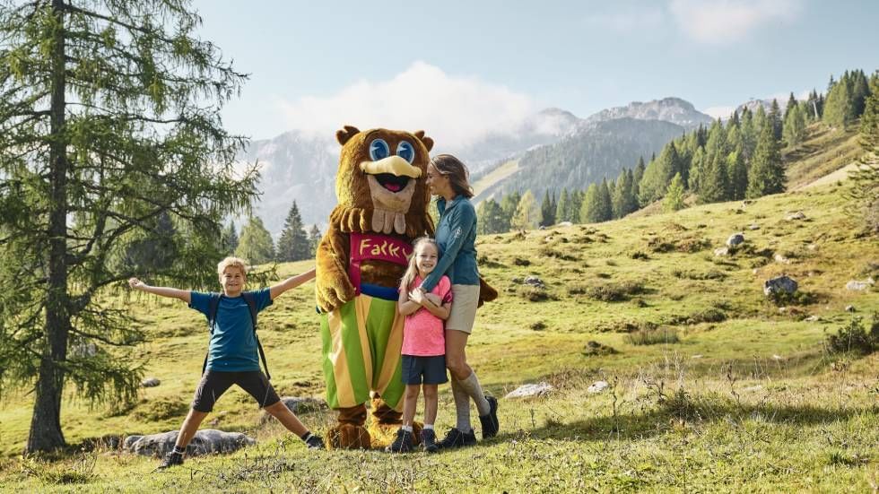 Mom and 2 kids posing with a mascot near Falkensteiner Hotels