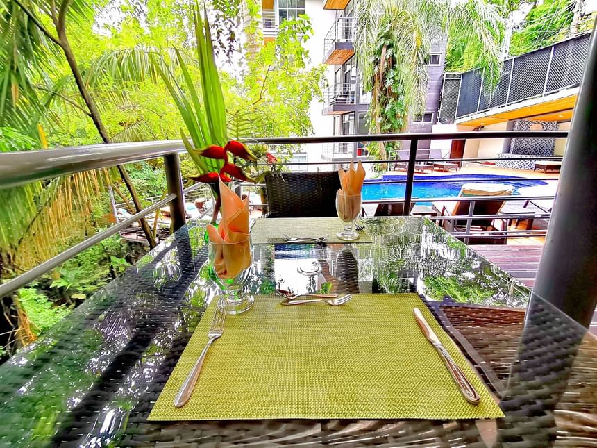 Mesas de comedor junto a la piscina al aire libre en Sloth Snack Bar en Jungle Vista Boutique Hotel