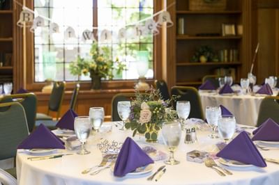 Dining table set with purple napkins and a floral centerpiece at The Boulevard Inn & Bistro