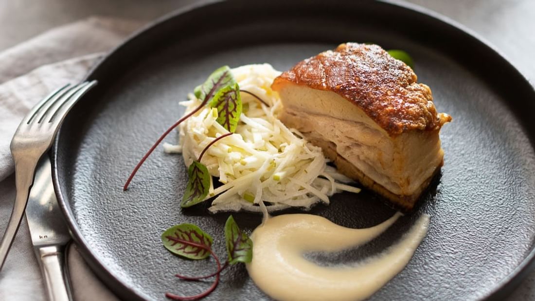 Crispy pork belly with apple slaw and sauce served in The Marke Kitchen at Novotel Sydney International Airport