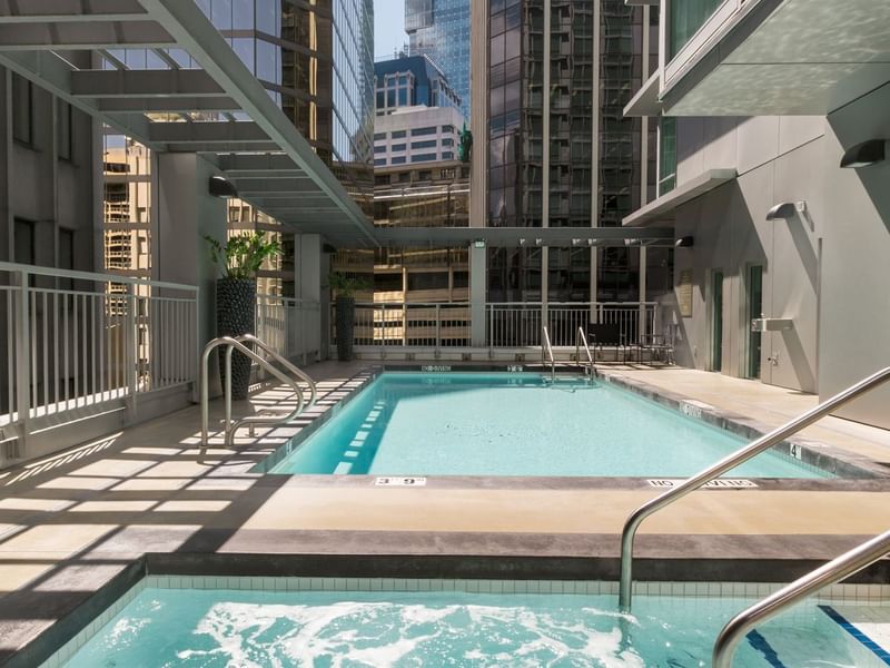 Outdoor pool and jacuzzi with view of city