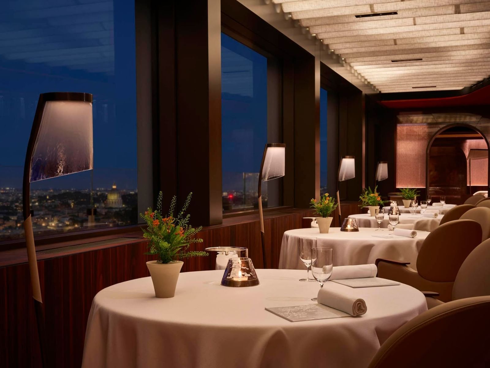 Elegant La Pergola interior with large windows, soft lighting, neatly set tables, and city views near The Guardian Hotel