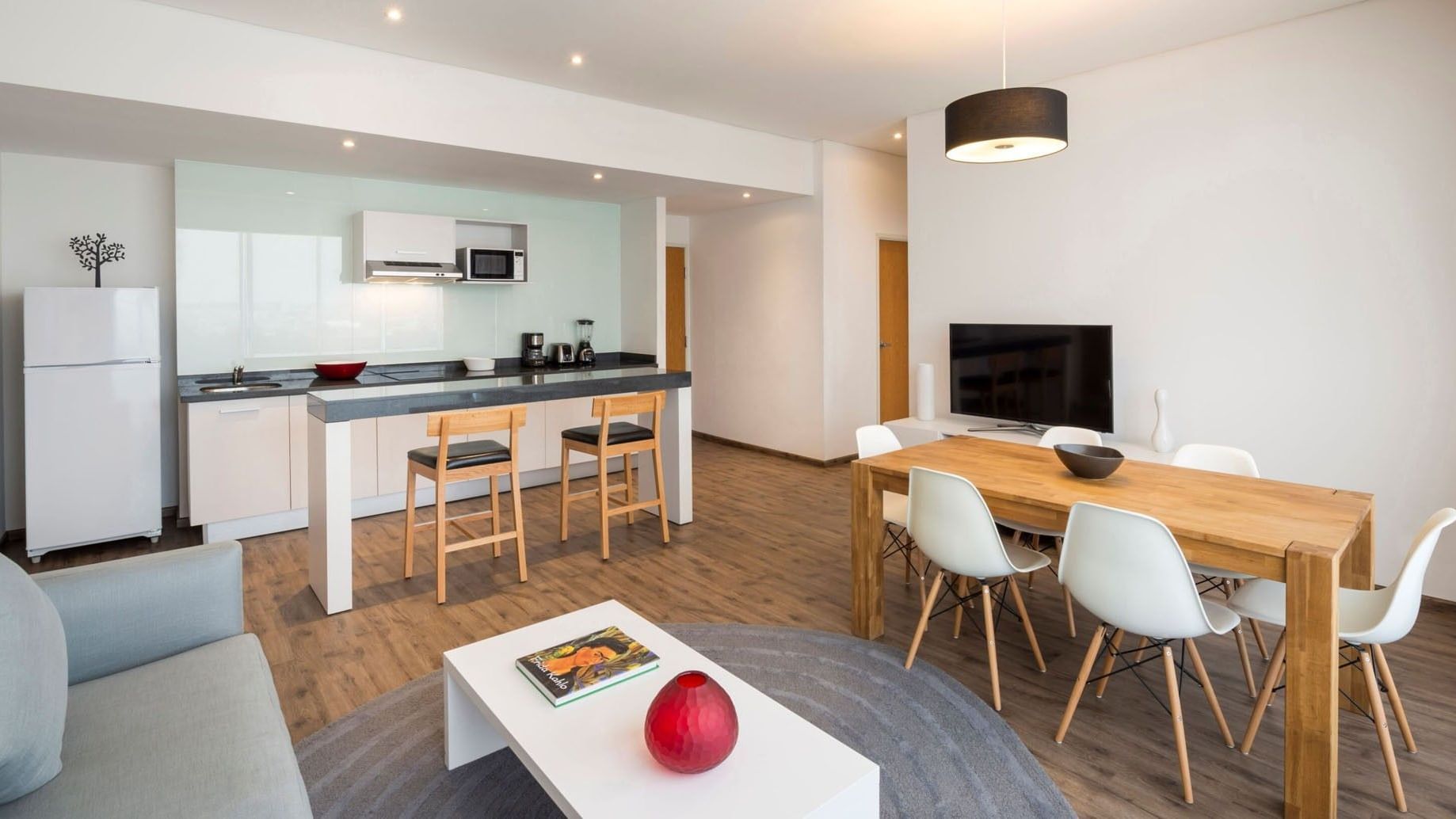 King Bed and 2 Double Beds Suite 2 Rooms featuring a modern kitchenette and a dining table at Camino Real Puebla Angelopolis