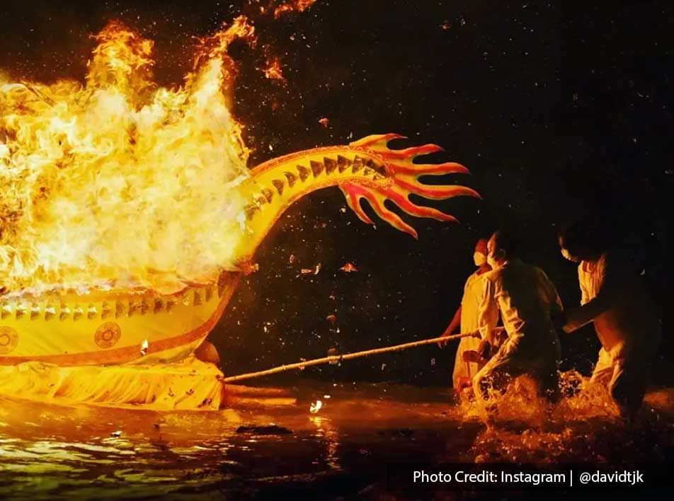 Sending off the 9 gods to the sea by lighting the dragon boats.