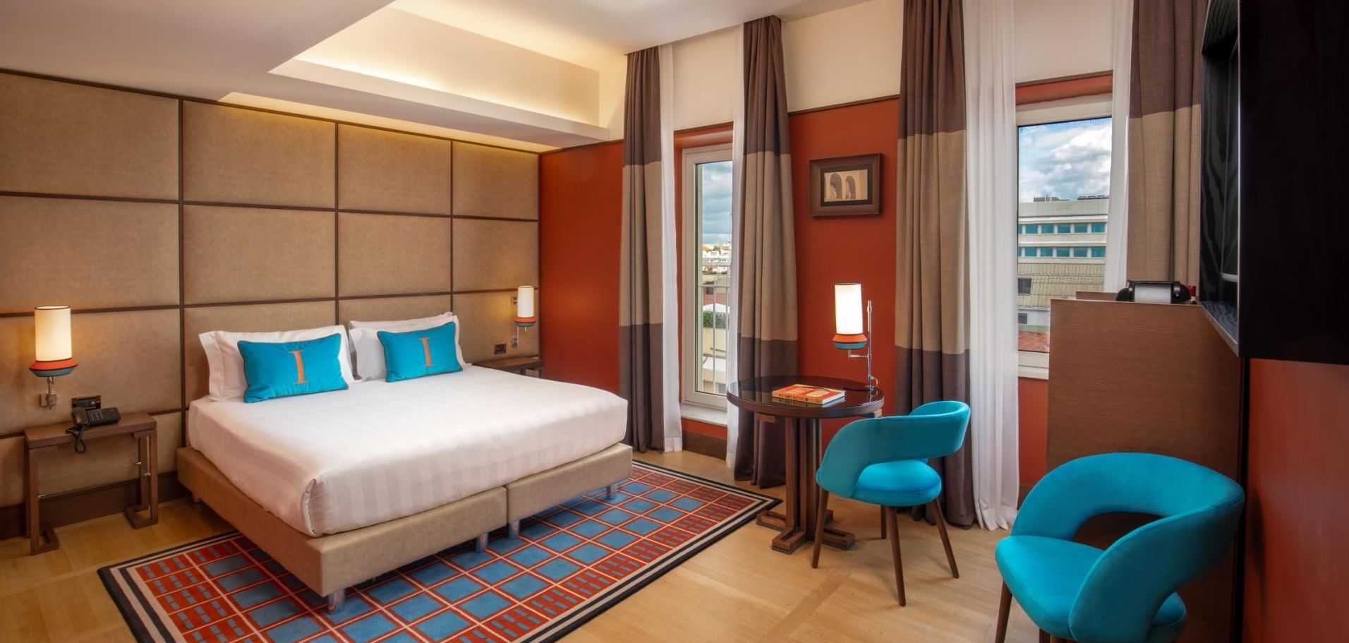 Modern Superior Room with a plush bed, wooden floors, and cozy seating by the window at The Independent