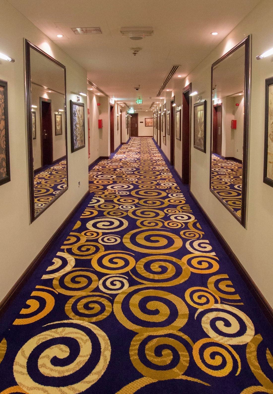 A long hallway with mirrors at Strato Hotel by Warwick Doha