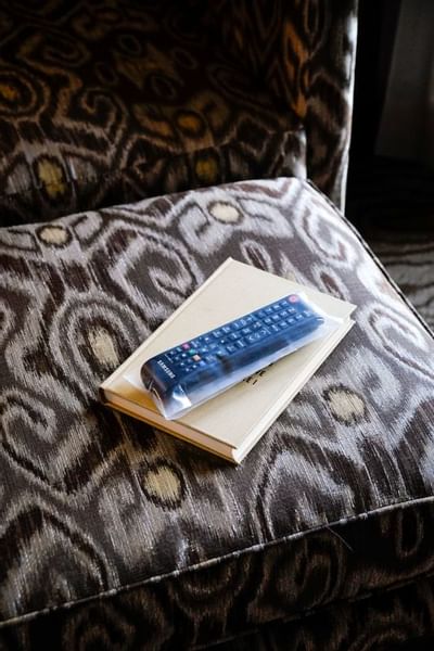 TV remote and a book on a chair at The Paramount Hotel Portland