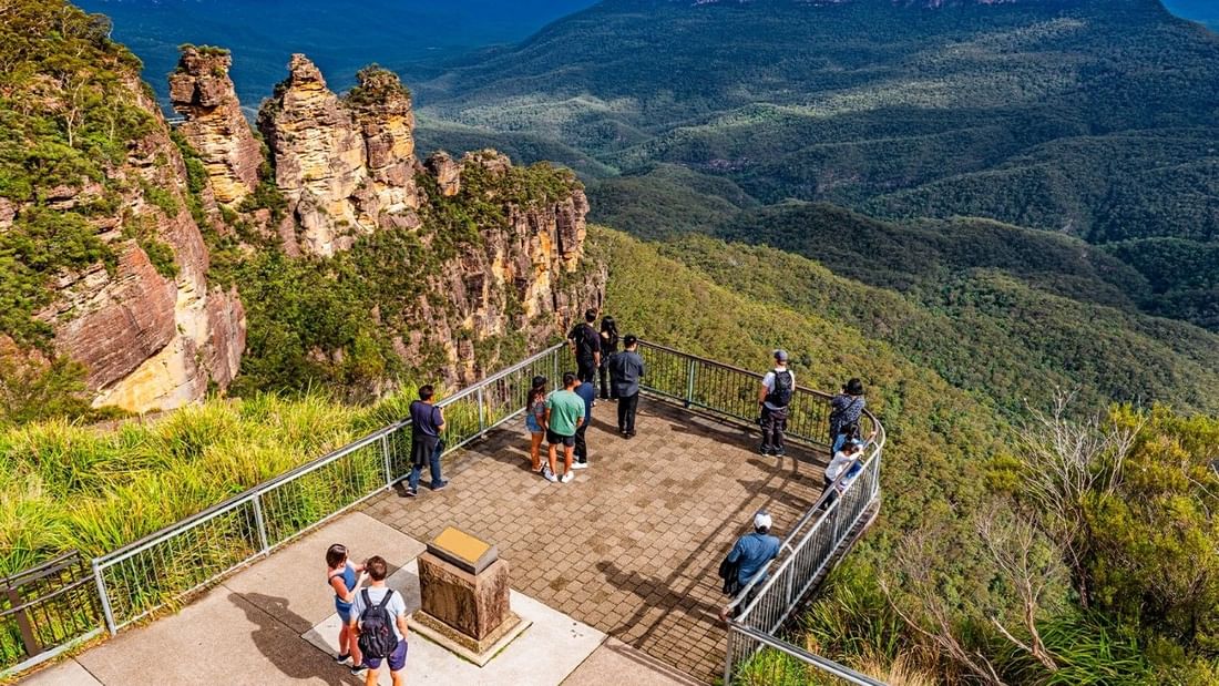 Tourists exploring Echo Point Walks and Talk with scenic mountain views.