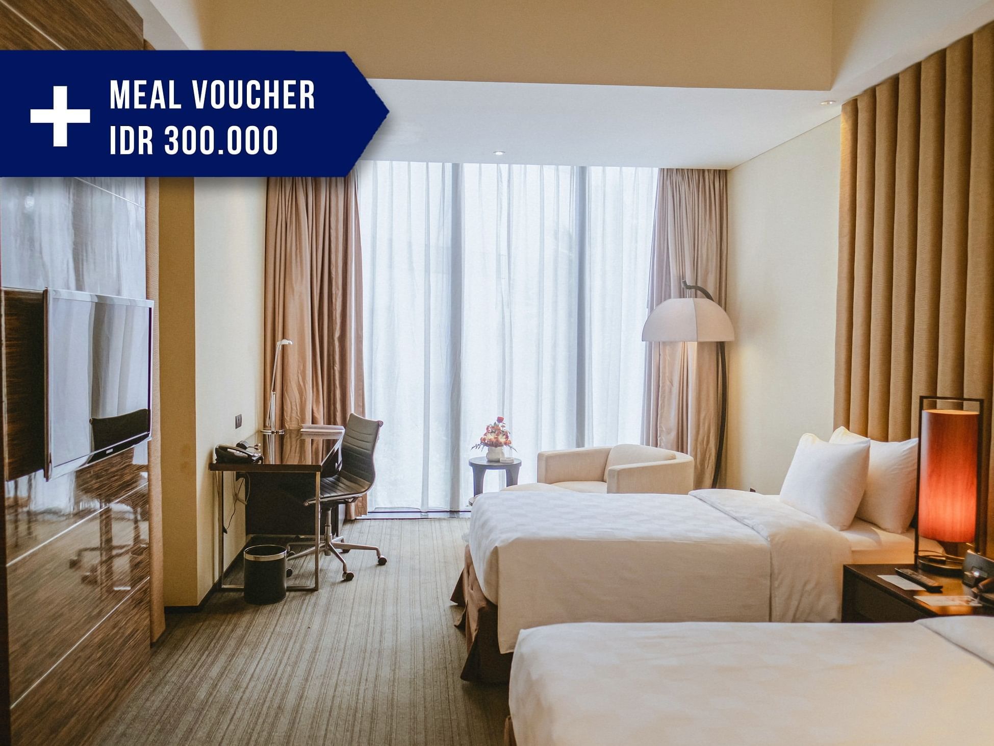 Hotel room with two beds, desk, TV, and