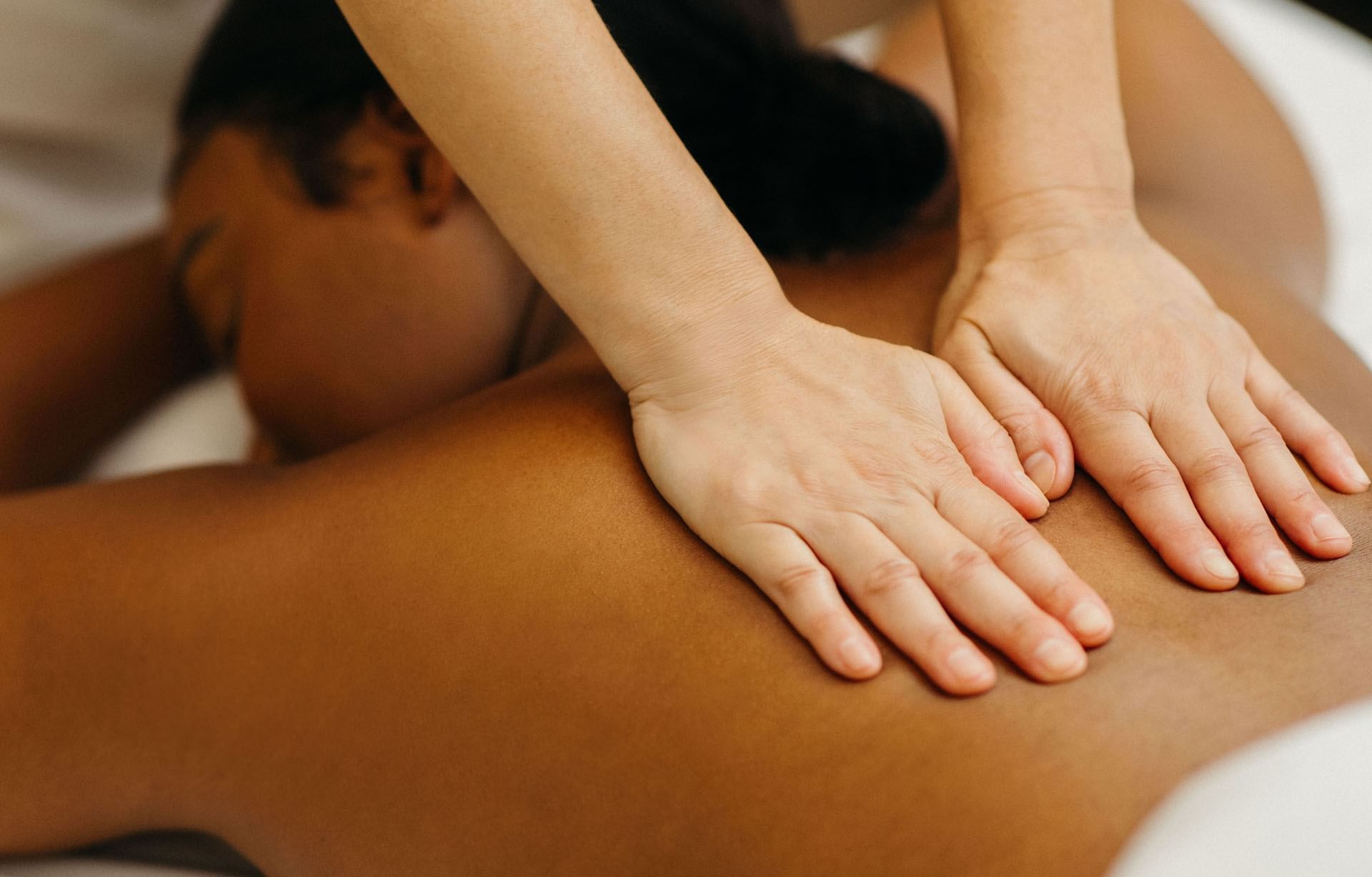 Close up view of therapist hands providing a back massage treatment to a woman at Guerlain Spa at Hotel X Toronto