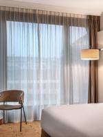 Élégante chambre Supérieure avec un grand lit, des rideaux et un bureau à l'hôtel Warwick Geneva à Genève.