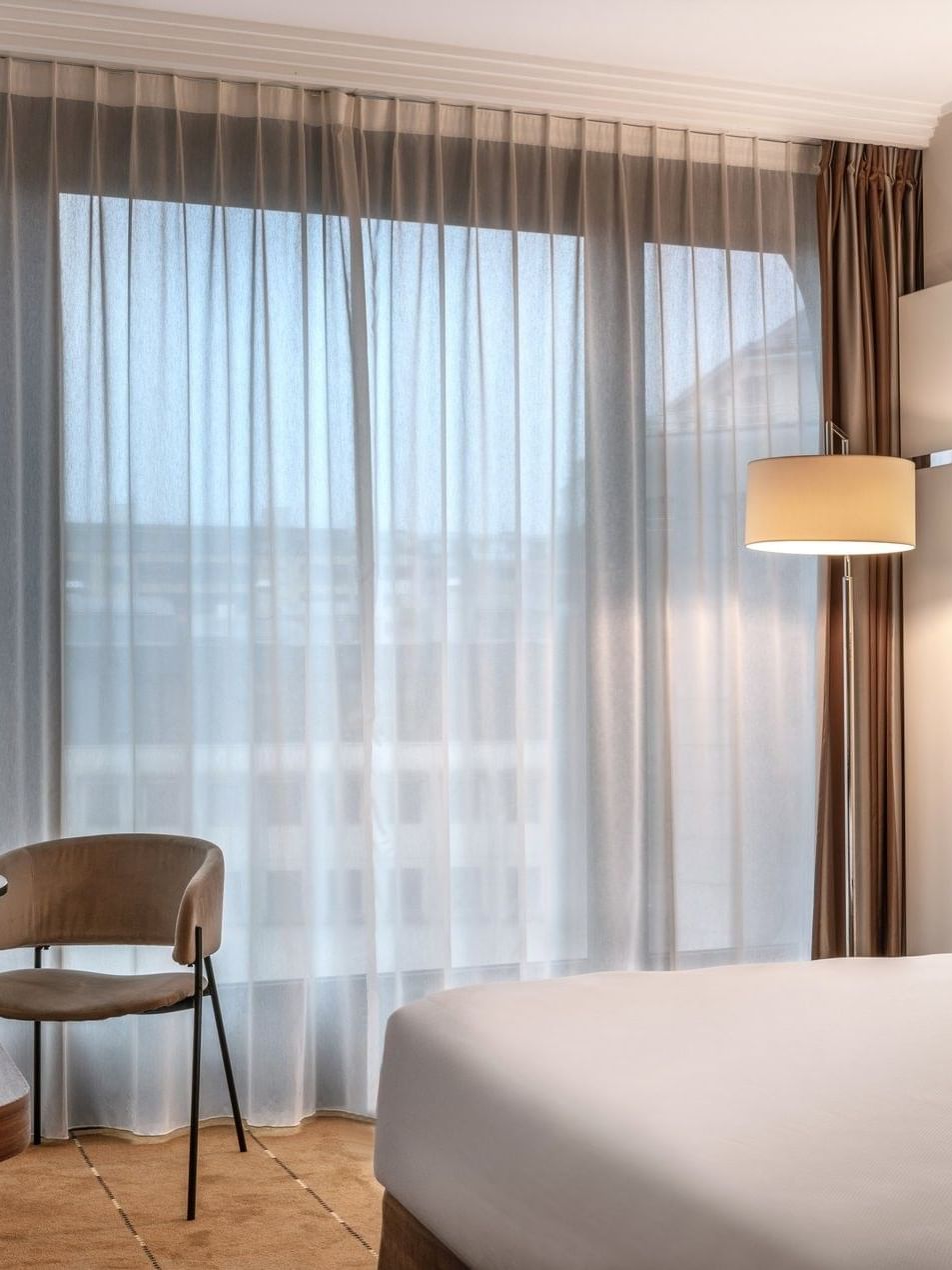 Élégante chambre Supérieure avec un grand lit, des rideaux et un bureau à l'hôtel Warwick Geneva à Genève.