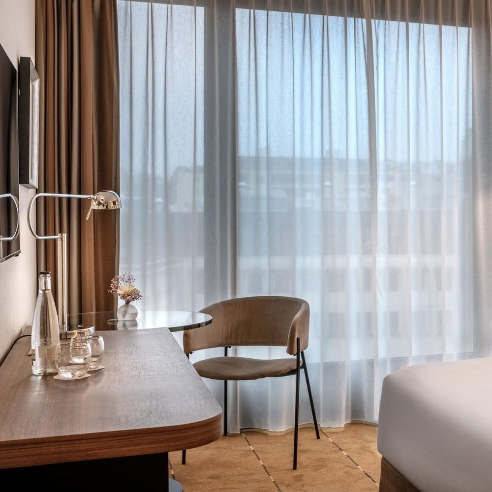Superior Room with a work desk by a large window, under sheer curtains near a wall lamp at Warwick Geneva