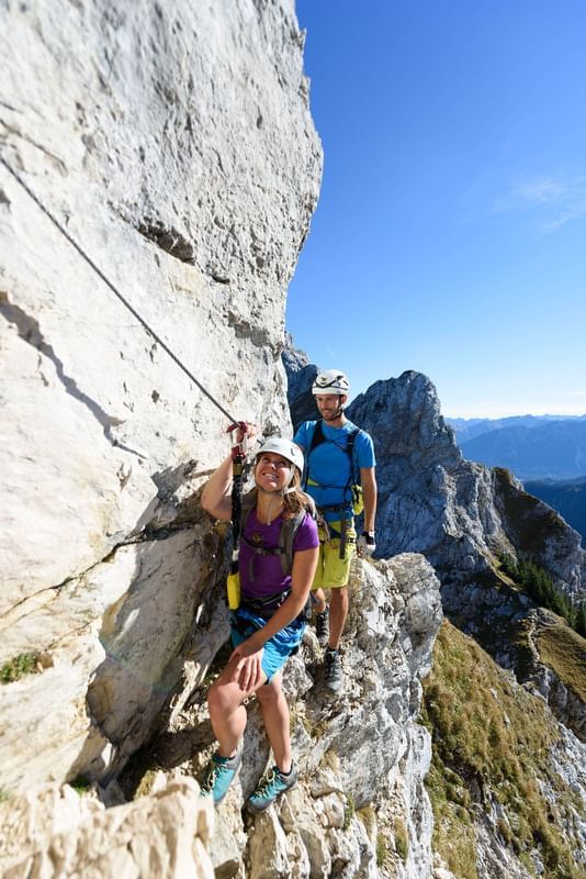 A couple climbing a rock near Liebes Rot Flueh
