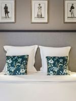 Cozy bed with a cushioned headboard and nightstands in the Premium Suite at Warwick Reine Astrid - Lyon