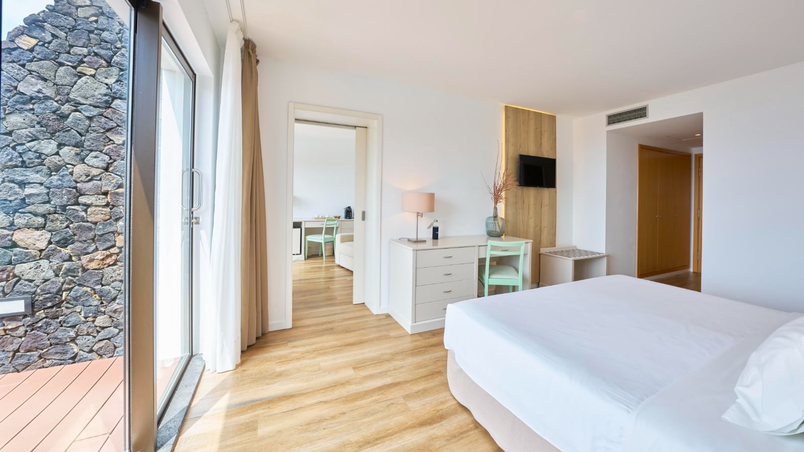 Workspace and TV facing the bed in Junior Suite with wooden flooring at Bensaude Hotels