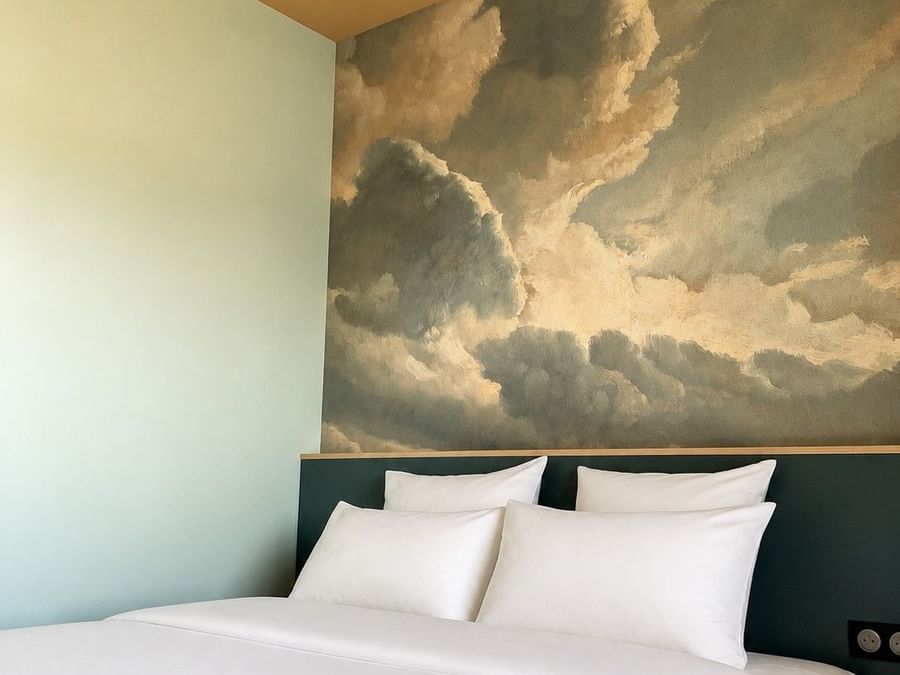 Chambre SUPERIEUR avec mur nuage et lit blanc à l'Osmo Hôtel Chantepie.