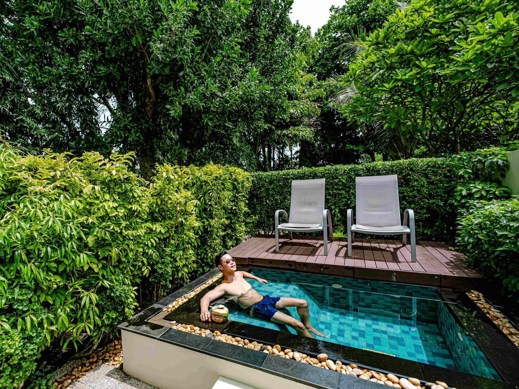 A man is dipping in the plunge pool in the private terrace of Paradox Courtyard room surrounded by tropical vibes