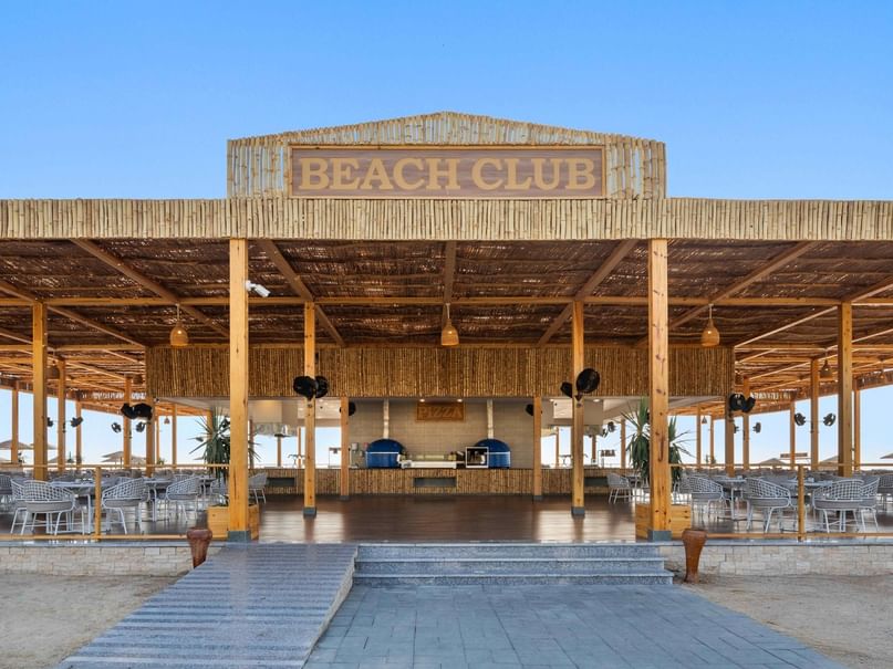 Open-air Beach Club with thatched roof, wooden bar, and seating area at Pickalbatros Palace Hotel - Port Ghalib