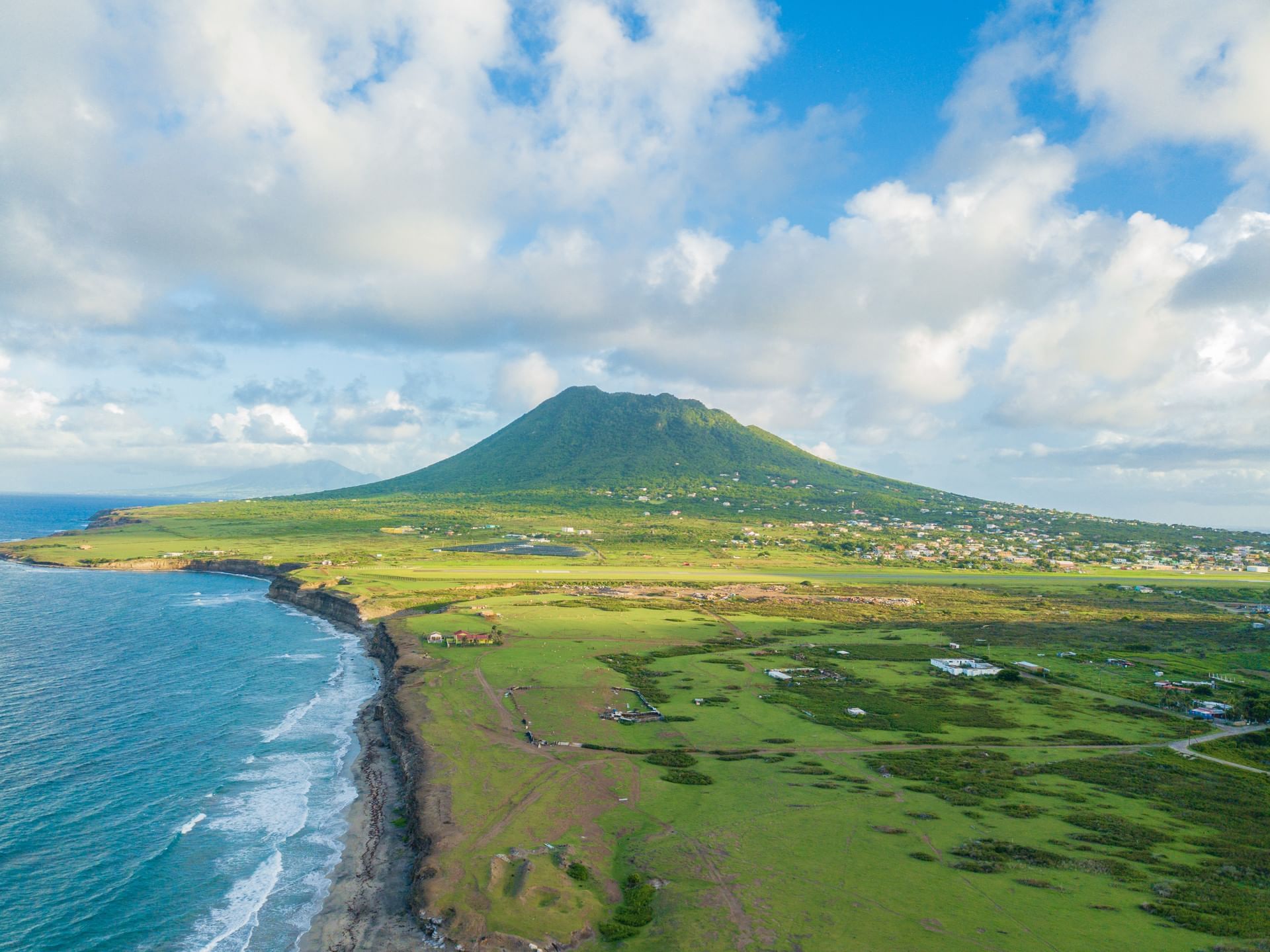 Uitzicht op de Mount Mazinga, een weelderig groene vulkanische eiland dat oprijst boven een zee nabij Golden Rock Resort