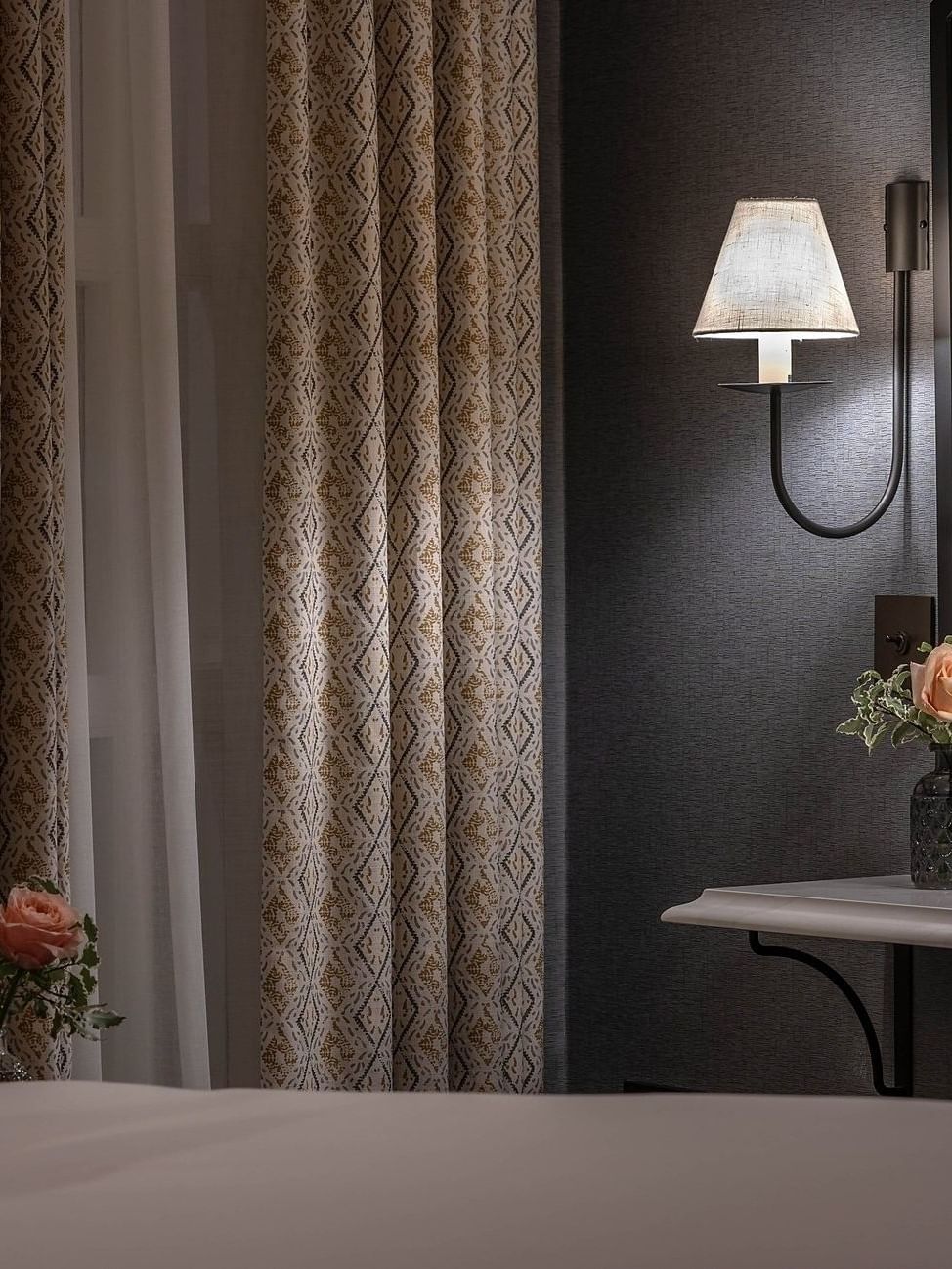 Elegant room interior with bed, curtains, and flowers at The Capital Hotel, Apartments & Townhouse