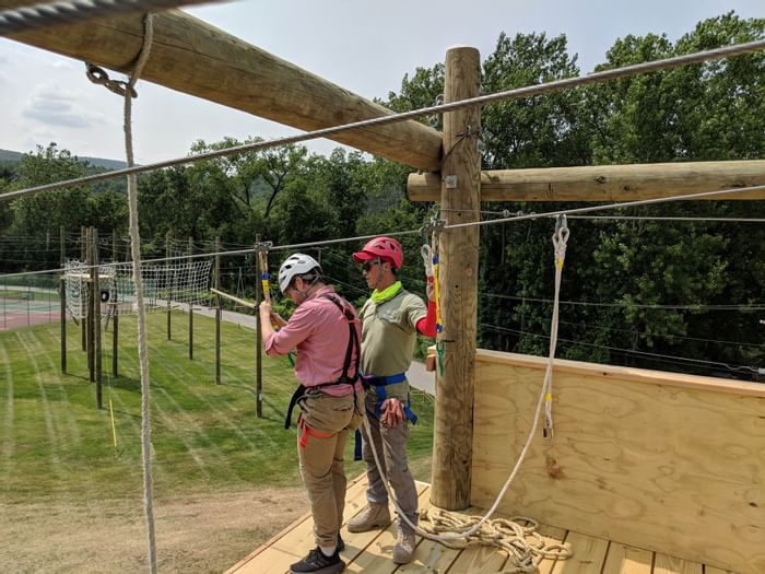 Man getting strapped into ropes course at Honor’s Haven