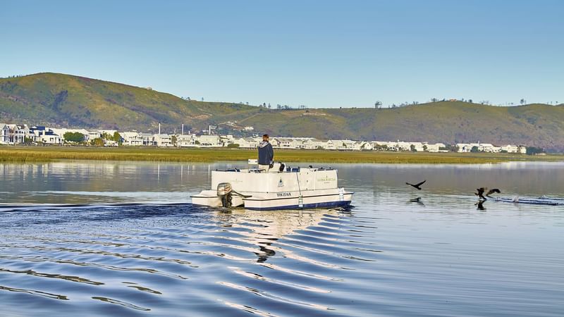 A man on a boat at the lake near Knysna River Club