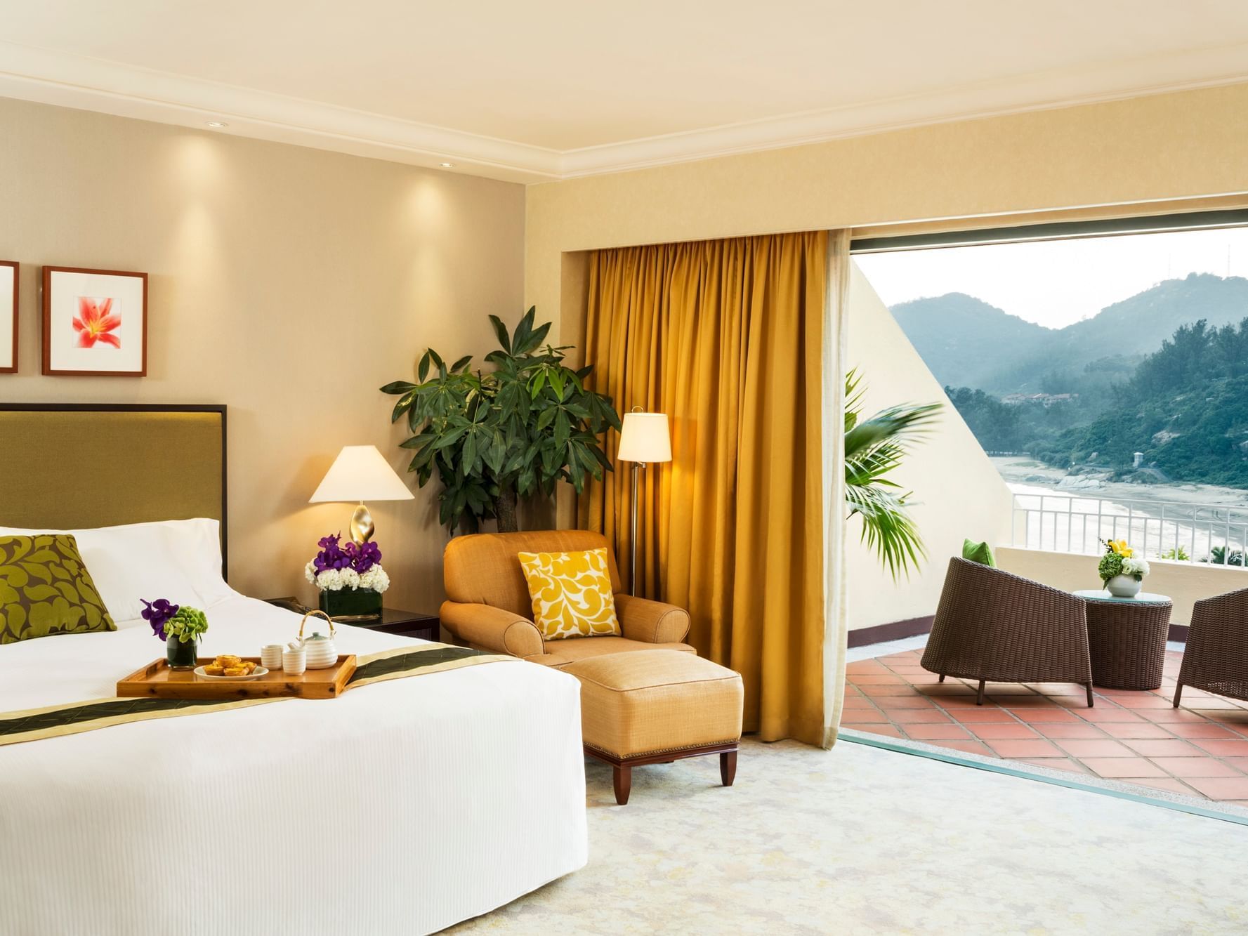 Bed, lounger & balcony in Grand Room at Grand Coloane Resort