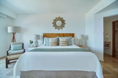 A premium resort bedroom design showing sliding glass doors that open to a scenic oceanfront balcony.