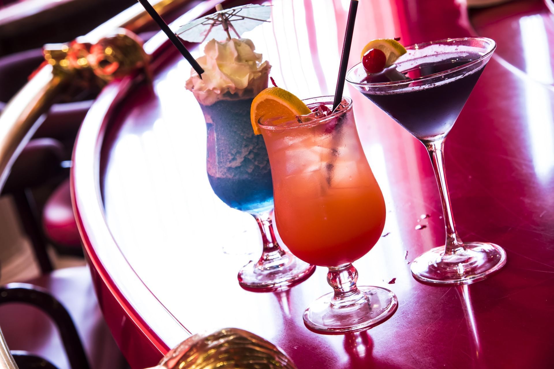 Three colorful cocktails served on a glossy red table at Cove Pocono Resorts