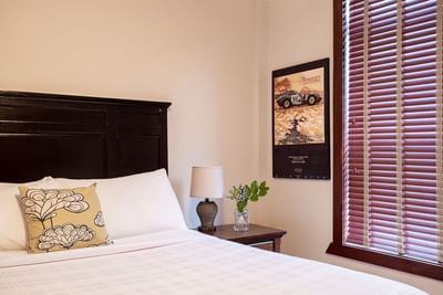 Bedroom with cozy bed & nightstand in Executive Residences at Retro Suites Hotel