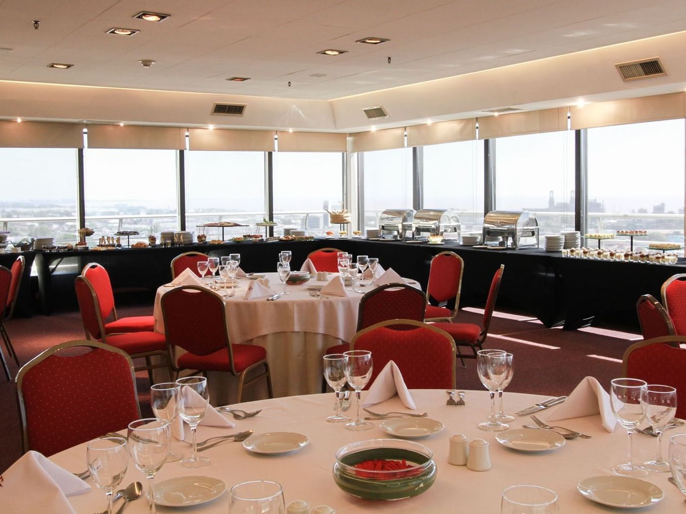 Puerta Del Sol (East) hall arranged with tables and red chairs at Hotel Emperador Buenos Aires