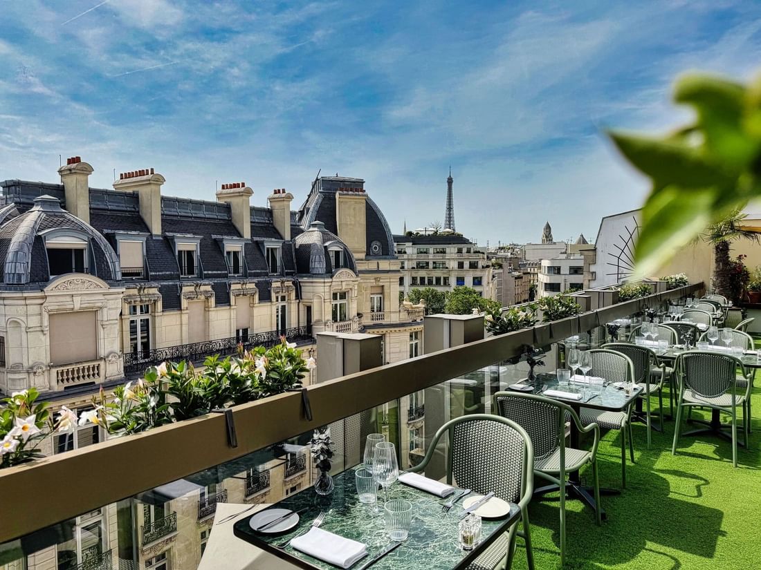 Rooftop terrace dining area with Eiffel Tower views and Parisian architecture at Warwick Paris Champs Elysées