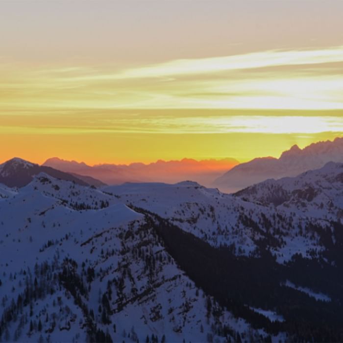 Sonnenuntergang über schneebedeckten Alpengipfeln bei Falkensteiner Hotel & Spa Carinzia