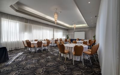 Meeting space set with banquet rounds and chairs.
